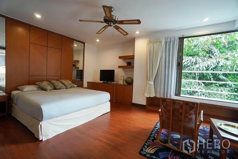 Apartment for rent in Watthana, Bangkok - Second bedroom with big window, built-in media unit and wood flooring.