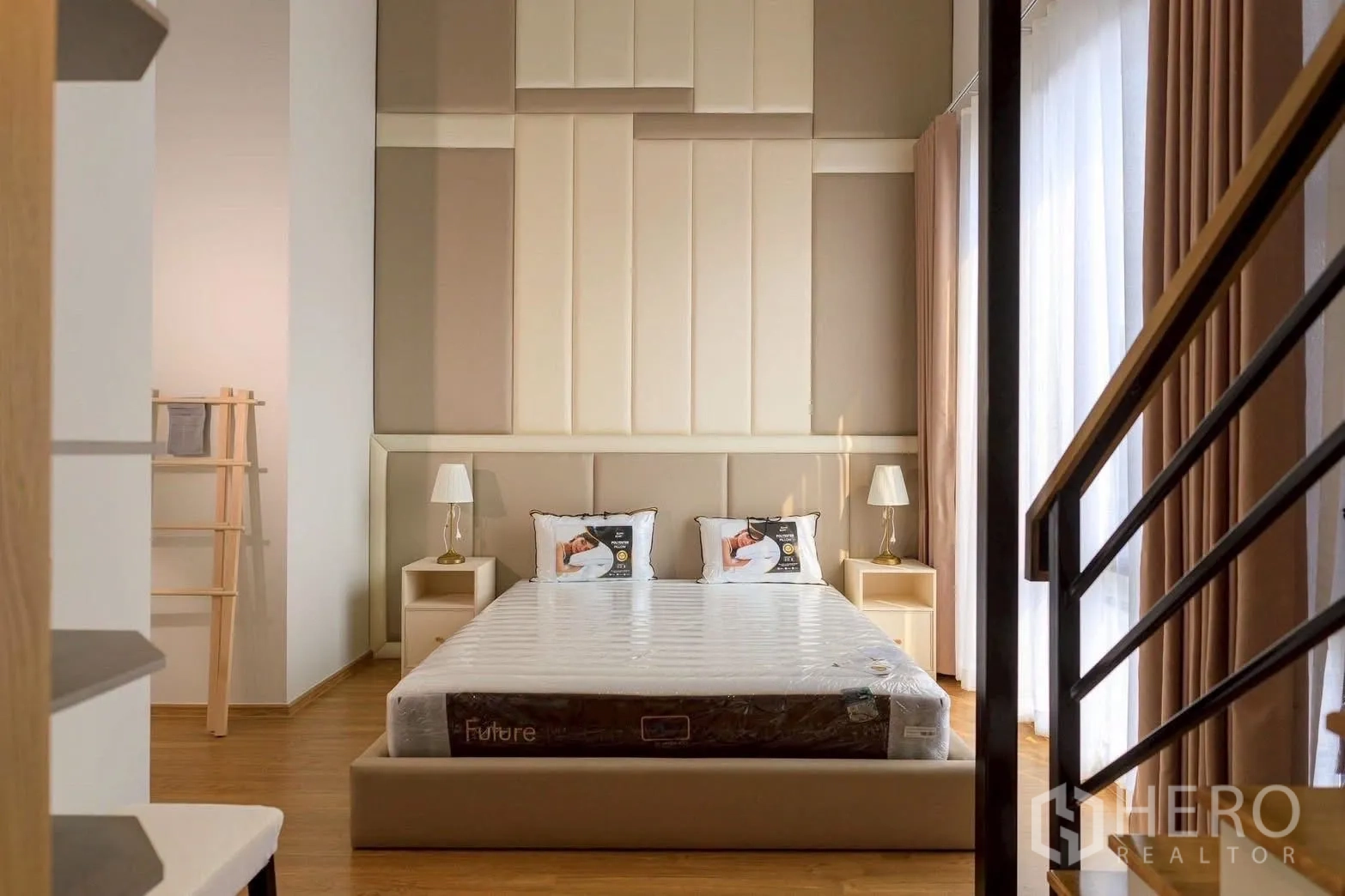 Townhouse for rent or sale in Bang Phli, Samut Prakan - Front view of the master bedroom with padded feature wall, bedside tables and staircase rail.