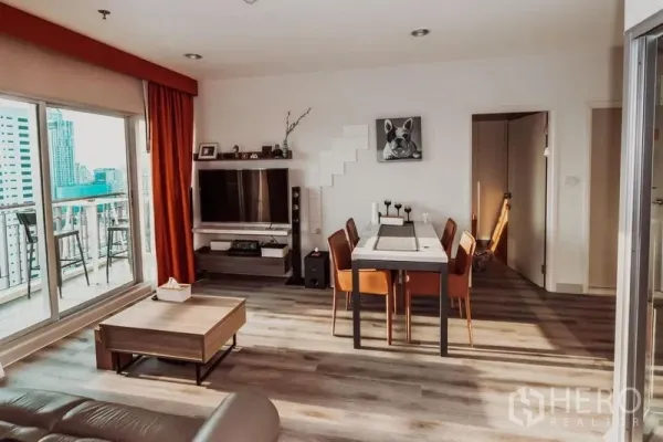 Condominium for rent in Sathon, Bangkok - Open-plan lounge with sliding doors to a balcony and wide city skyline views.