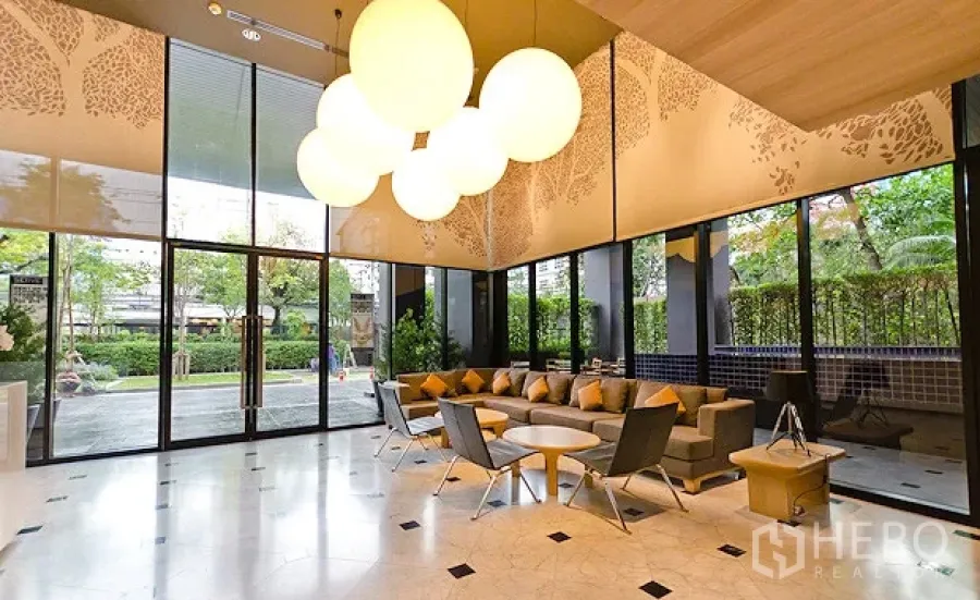 Condominium for rent or sale in Watthana, Bangkok - Bright condominium lobby with marble floors, designer pendant lights, and garden views in Ekkamai, Watthana, Bangkok.
