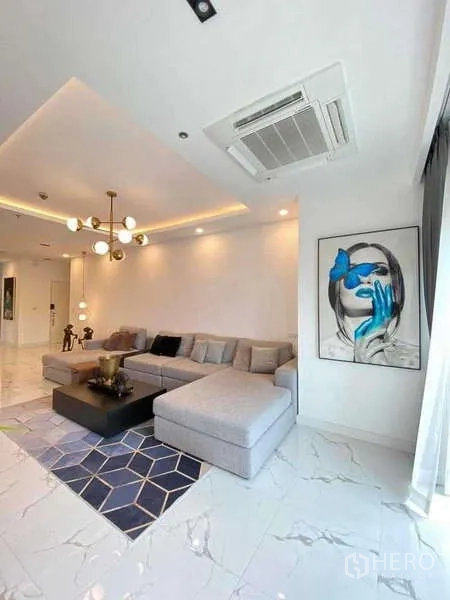 公寓 出租或出售在Watthana, Bangkok - 客厅一角，现代艺术画作、L形沙发与吊顶空调。