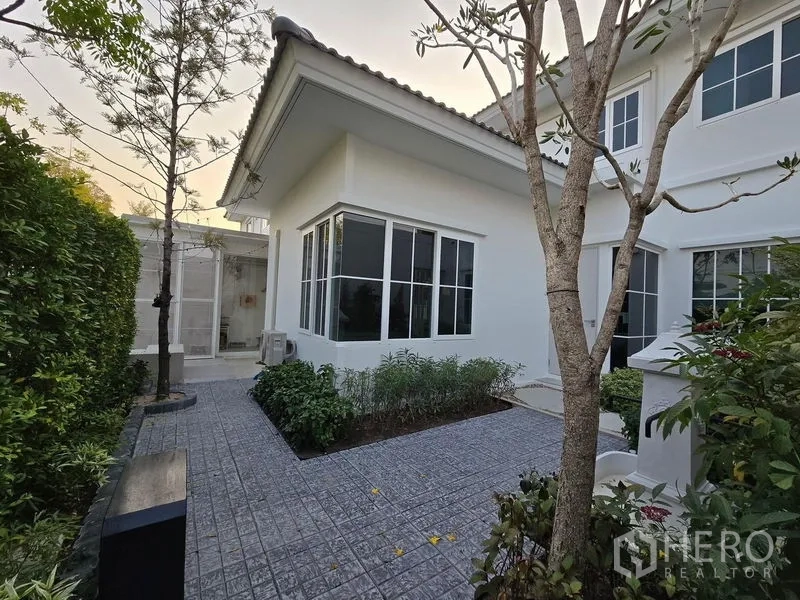 Detached House for rent in Bang Phli, Samut Prakan - Rear garden and bay‑window extension with paved patio and greenery.