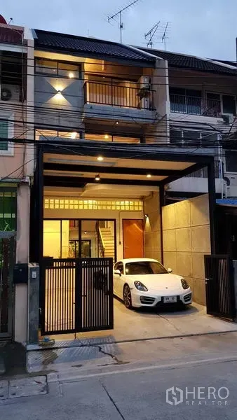 ทาวน์เฮาส์ ให้เช่าในKhlong Toei, Bangkok - ทาวน์เฮ้าส์ 3 ชั้นยามค่ำมีกันสาดและที่จอดรถพร้อมประตูรั้วเหล็ก.