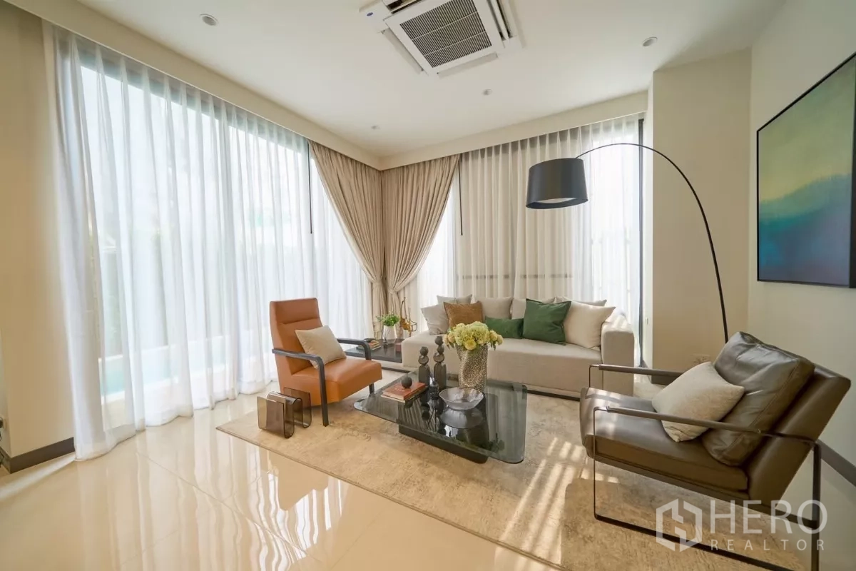 Detached House for sale in Lat Phrao, Bangkok - Bright family lounge with full-height windows, sheer drapes and contemporary seating.