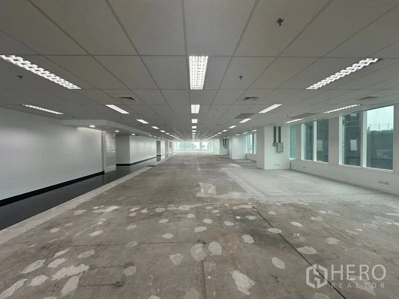 สำนักงาน ให้เช่า - มุมชั้นสำนักงานพร้อมหน้าต่างเอียงและฉากหลังเป็นวิวเมือง