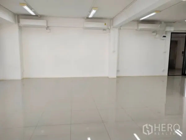 办公空间 出租在Bang Na, Bangkok - 装有分体空调与长条灯的办公室内部，地面光亮。