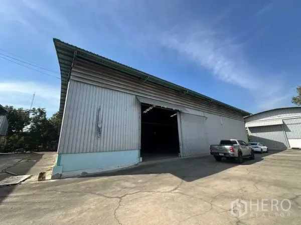 Warehouse for rent in Phra Nakhon Si Ayutthaya - Front view of the warehouse showing large sliding doors and truck parking area.
