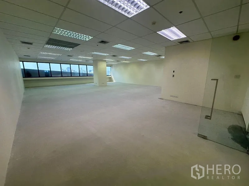 Office Space for rent in Bang Na, Bangkok - Spacious open-plan office with grid ceiling lights and a long run of windows providing city views.