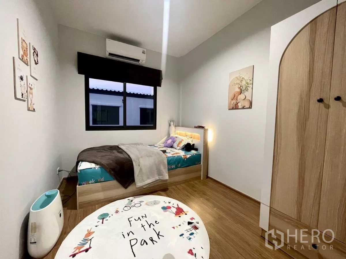 Townhouse for rent in Samut Prakan - Kids’ bedroom with single bed, wood flooring and arched-door wardrobe.