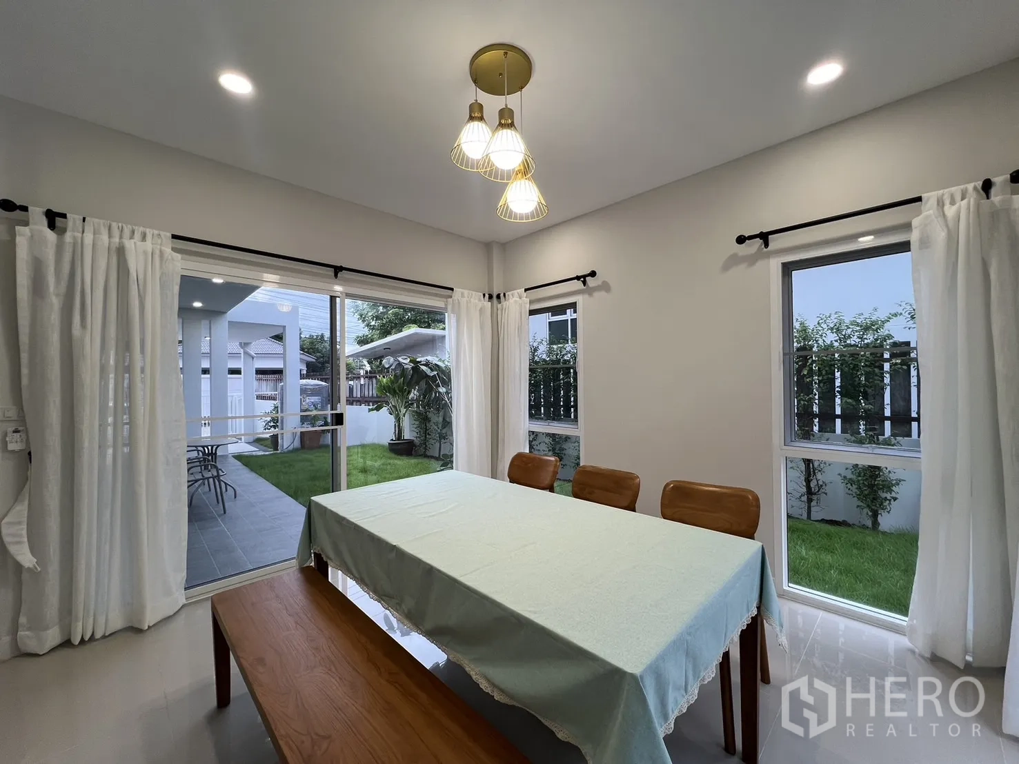 Detached House for rent in Saphan Sung, Bangkok - Dining room with sliding doors opening to the lawn and covered terrace.