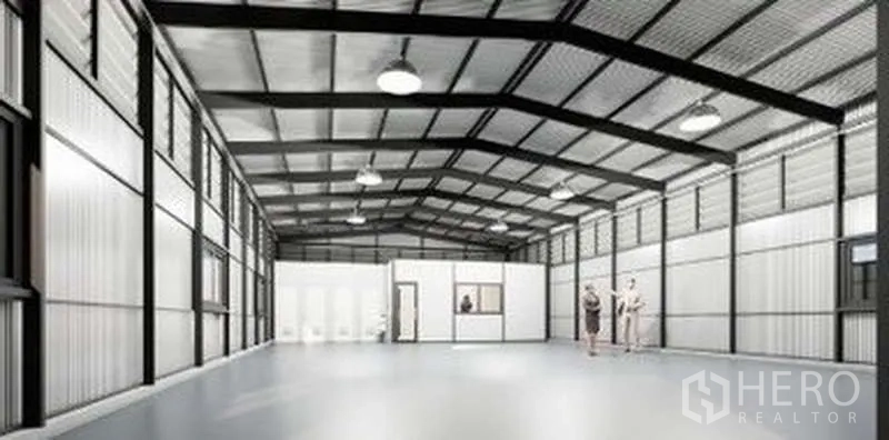 Warehouse for rent in Lat Phrao, Bangkok - Bright warehouse hall showing partitioned office rooms and restrooms with smooth flooring and suspended lights.