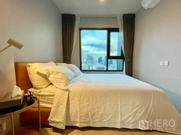 公寓 出租在Pathum Wan, Bangkok - 温馨卧室，大窗户可欣赏曼谷天际线。