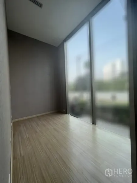 Retail Space for rent in Watthana, Bangkok - Compact interior corner with floor-to-ceiling windows and light wood flooring.