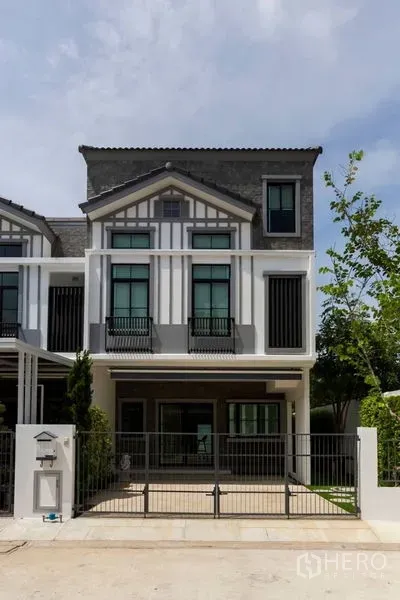 Townhouse for rent in Bang Phli, Samut Prakan - Modern three-storey townhouse facade with gated driveway and tall windows in Bang Phli.