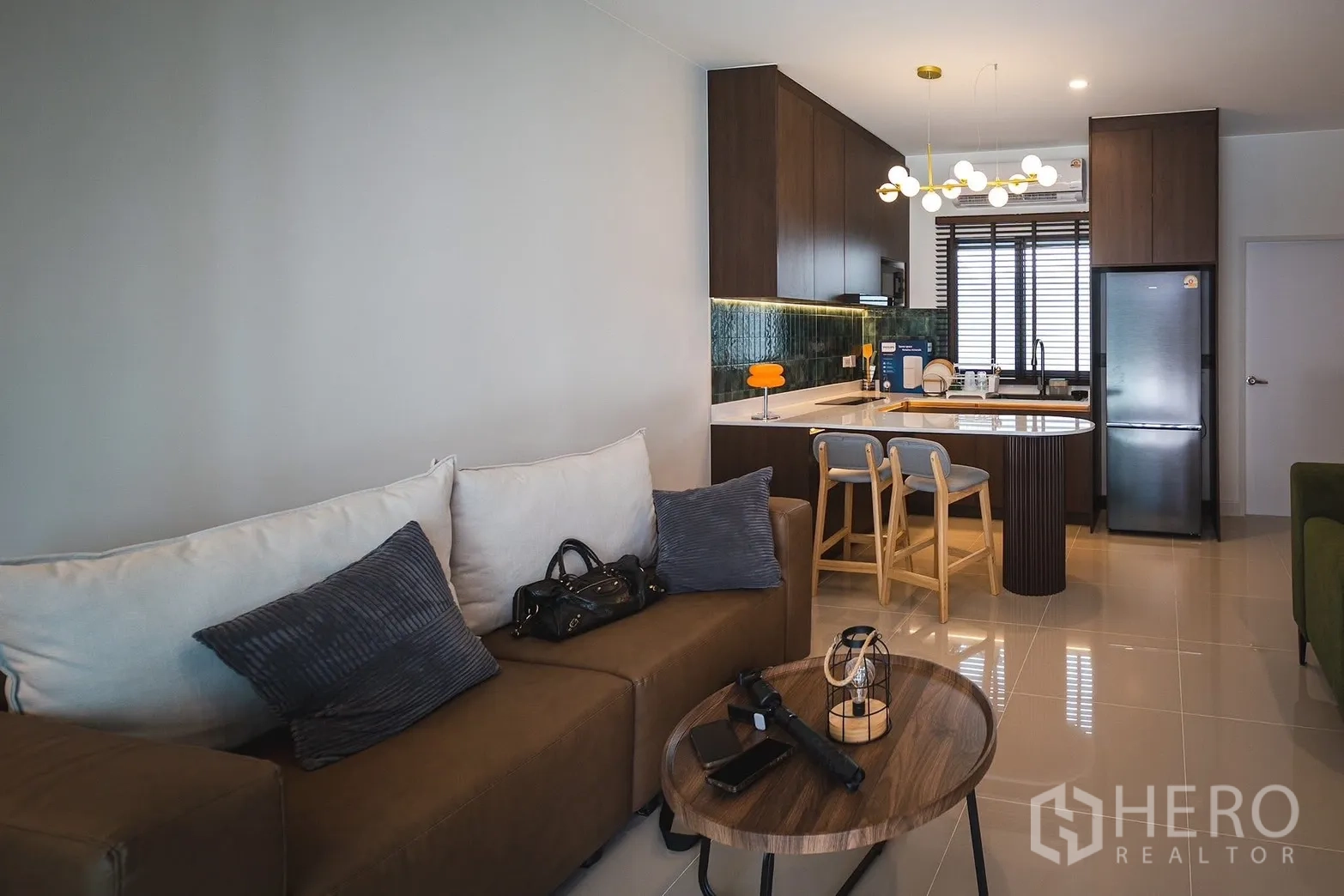 Townhouse for rent in Bang Phli, Samut Prakan - Living room facing the kitchen island with pendant lights and bar stools.