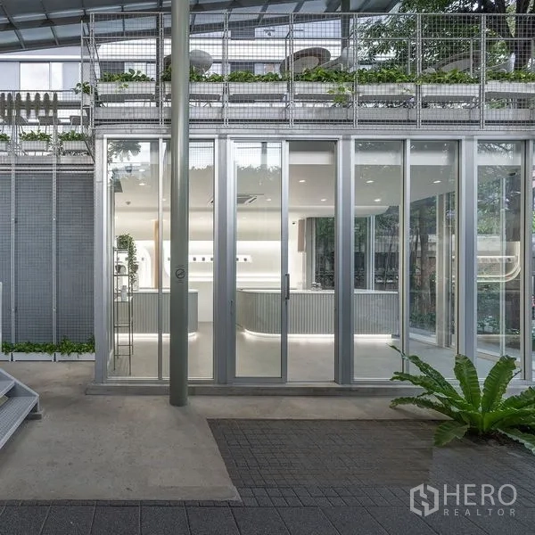 Retail Space for rent in Khlong Toei, Bangkok - Street-level exterior with sliding glass doors, metal facade and greenery at a contemporary retail space.