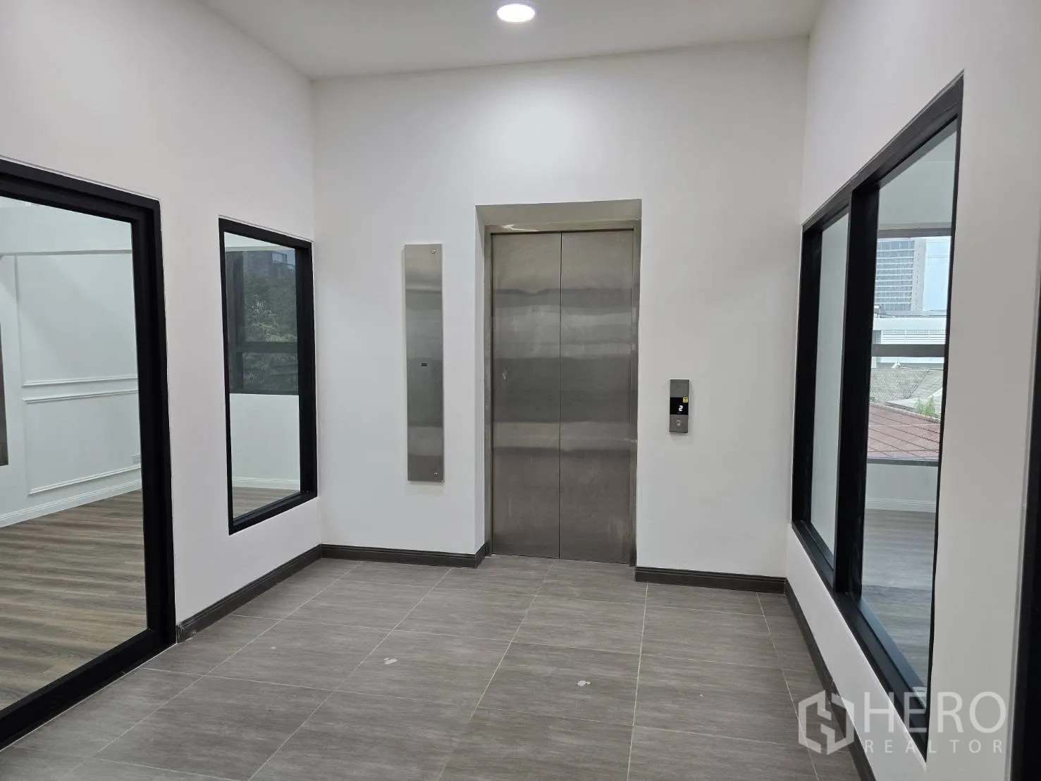 Home Office for rent in Chatuchak, Bangkok - Interior lobby featuring a stainless-steel elevator and glass-walled rooms.