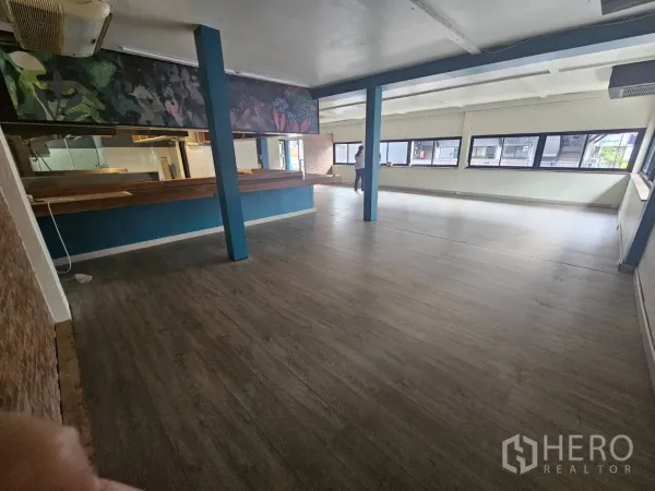 Retail Space for rent in Watthana, Bangkok - Large open-plan retail floor with blue columns and long windows for natural light.