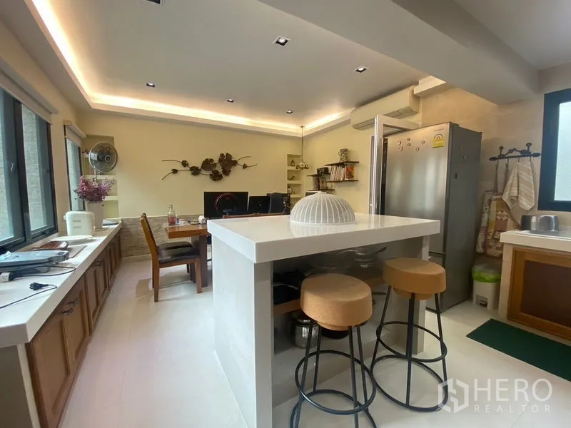 独立式住宅 出售在Khlong Toei, Bangkok - 现代厨房，中岛吧台、吧椅与不锈钢冰箱。