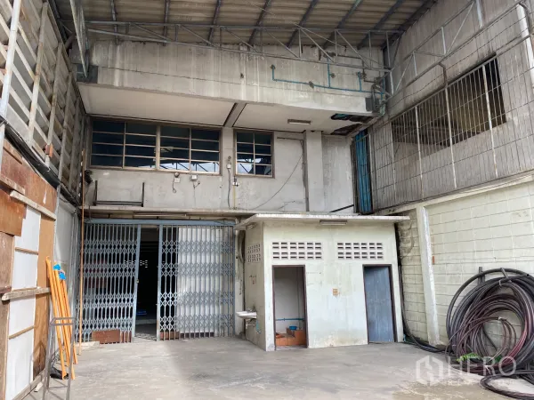 Retail Space for rent in Yan Nawa, Bangkok - High-ceiling covered loading bay with metal sliding gates and a small restroom block.