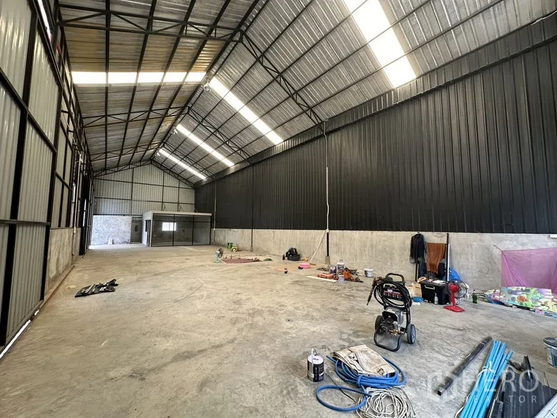 Warehouse for rent in Lat Phrao, Bangkok - Deep clear-span warehouse with skylight panels and concrete slab floor.