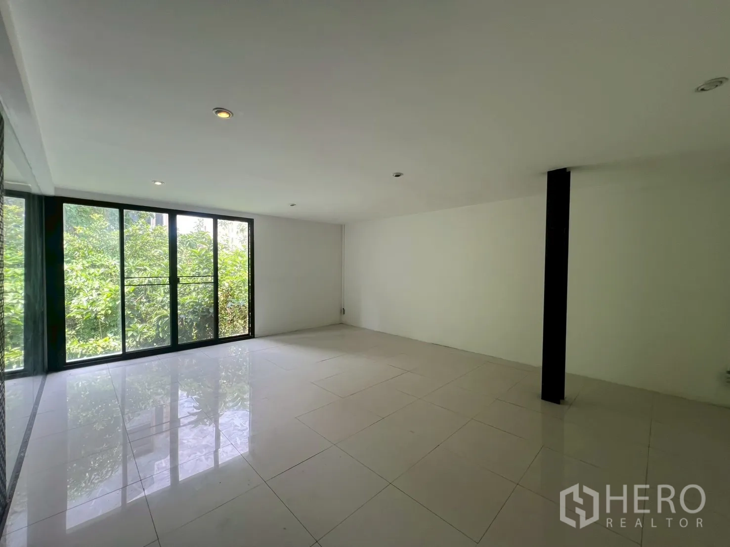 Home Office for rent in Watthana, Bangkok - Bright room with large sliding glass doors opening to greenery views.