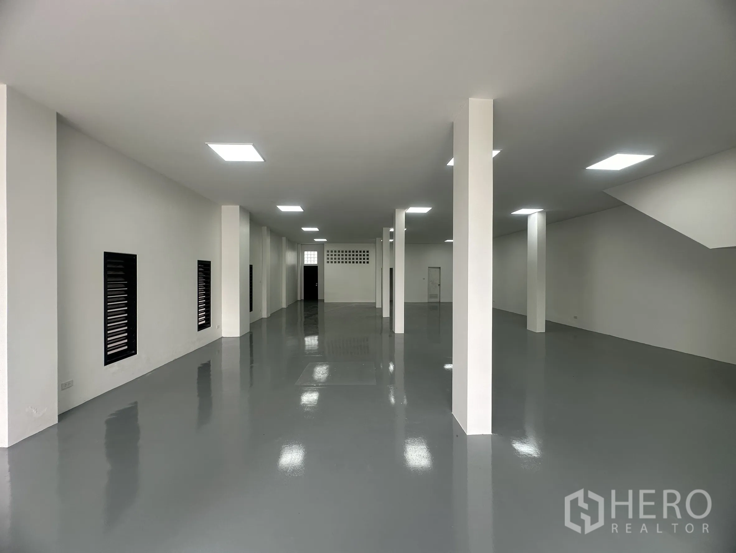 货栈 出售在Khlong Luang, Pathum Thani - 仓库内部，环氧地坪、白墙、立柱与LED平板灯。
