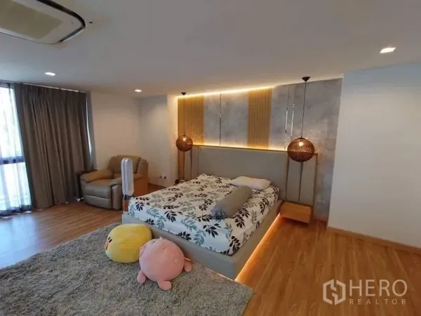 联排别墅 出售在Lat Phrao, Bangkok - 主卧空间宽敞，木地板，灯带床头与休闲椅。