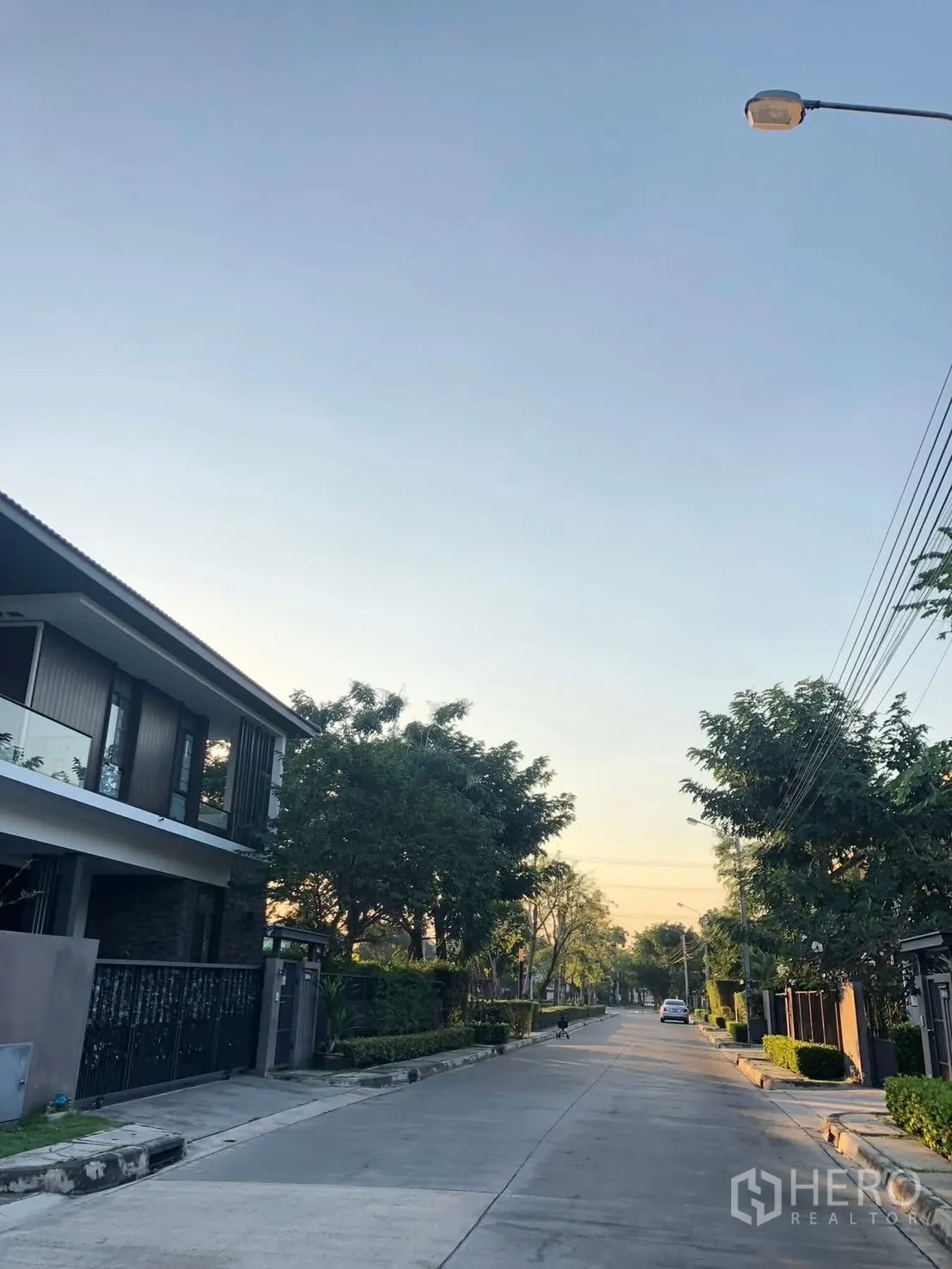 Detached House for rent in Prawet, Bangkok - Tree-lined residential street with modern houses and sidewalks.
