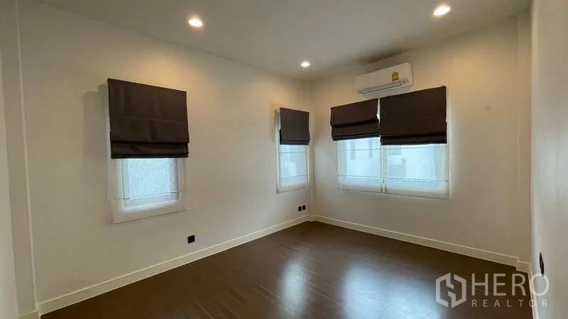 Detached House for rent in Bang Kapi, Bangkok - Bright bedroom with air conditioner and three windows with blinds.