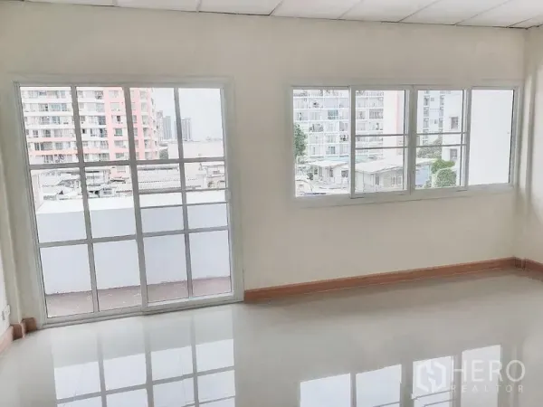 Townhouse for rent in Chatuchak, Bangkok - Bright room with large grid windows and city views from a Chatuchak townhouse.