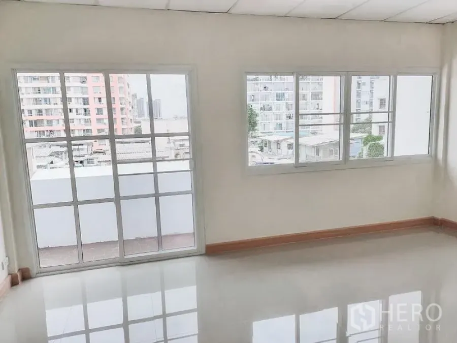 Townhouse for rent in Chatuchak, Bangkok - Bright room with large grid windows and city views from a Chatuchak townhouse.