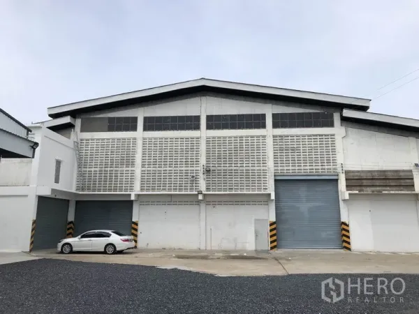 货栈 出租在Pathum Thani - 白色高层高仓库正立面，设多道卷帘门与停车场，位于Bang Kadi巴吞他尼。