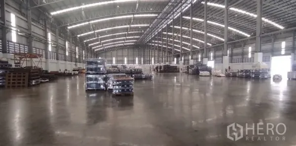 货栈 出租在Nong Chok, Bangkok - 超大无柱仓储大厅，天窗采光充足，托盘整齐摆放在光滑混凝土上。