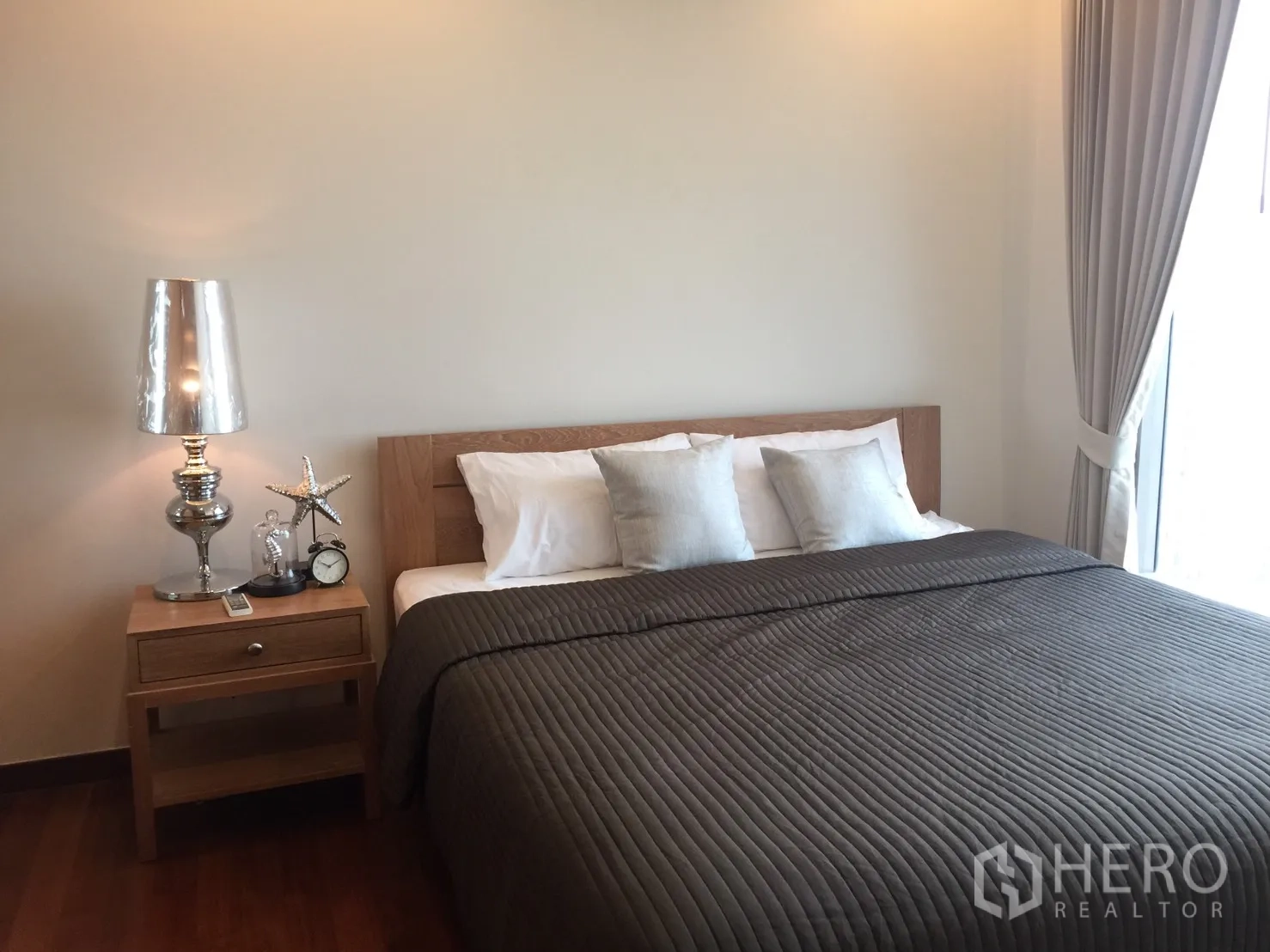 Condominium for rent in Khlong Toei, Bangkok - Serene bedroom with double bed, bedside table and full-height curtains.