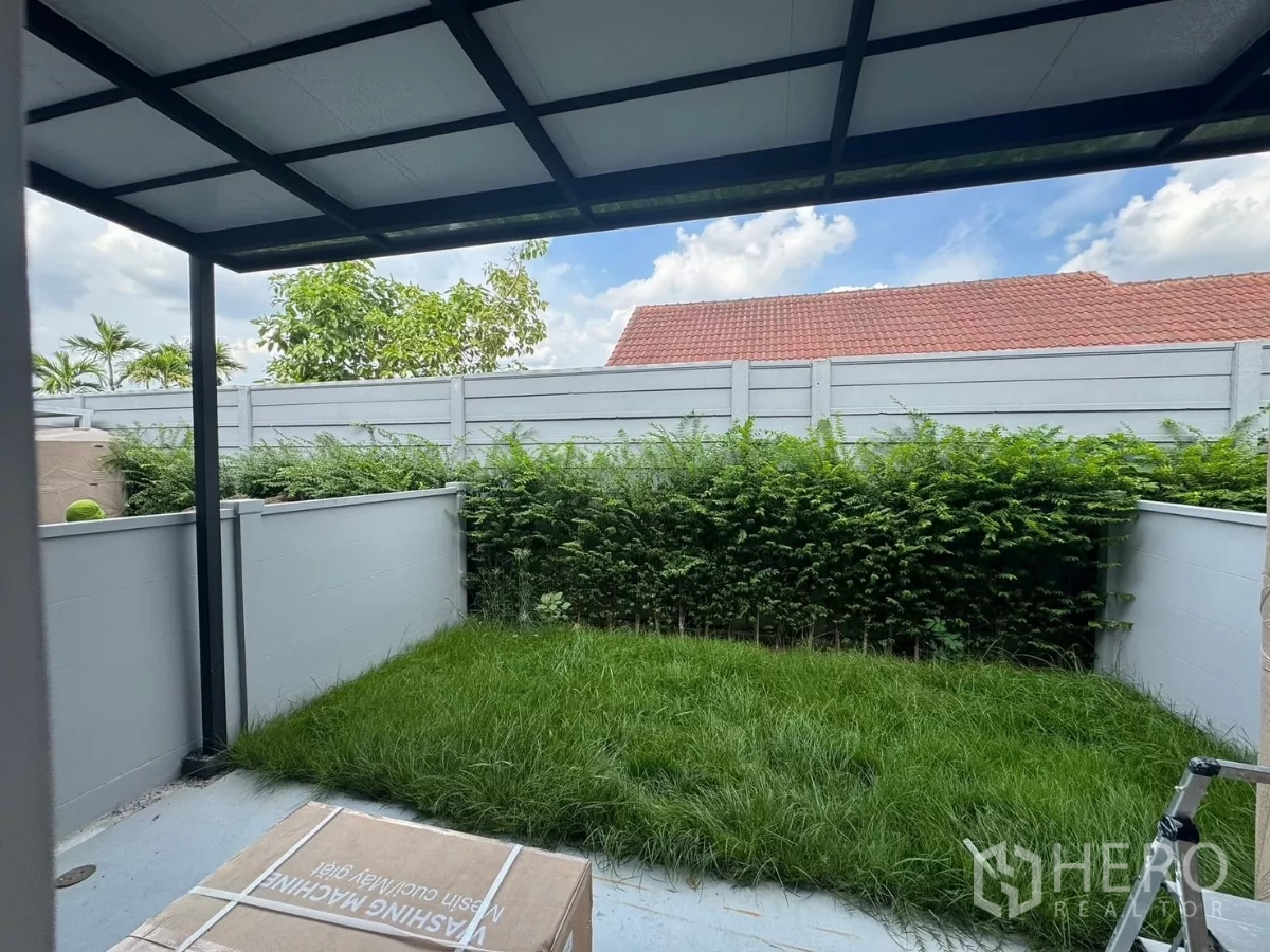 Townhouse for rent in Bang Phli, Samut Prakan - Backyard with covered terrace and small lawn bordered by hedges