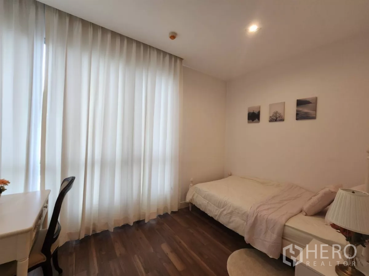 Condominium for rent in Phra Khanong, Bangkok - Second bedroom with study desk by a large window and single bed.