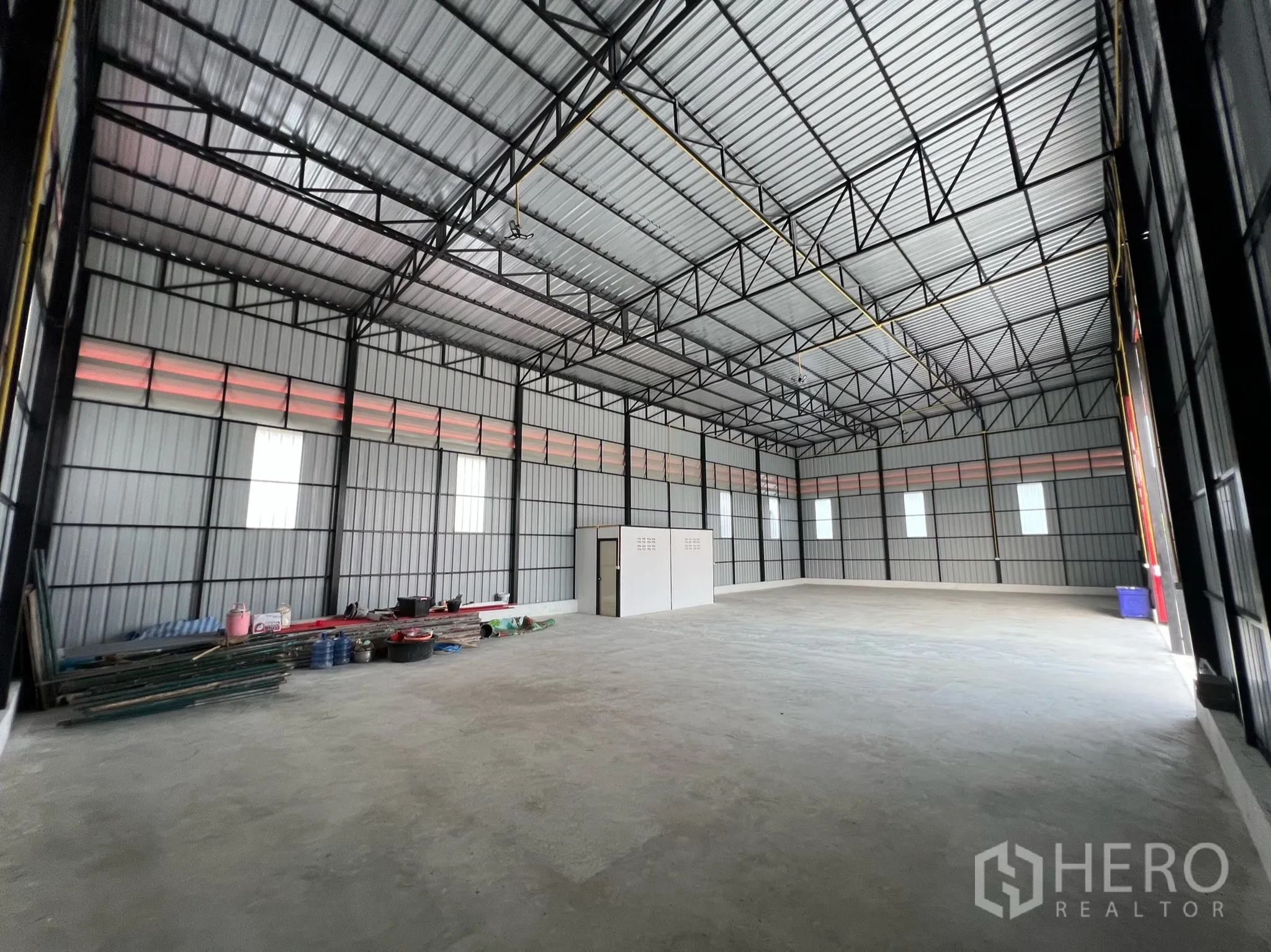 Warehouse for rent in Lam Luk Ka, Pathum Thani - High-ceiling steel-frame warehouse interior with concrete floor and windows, approx. 270 sqm.
