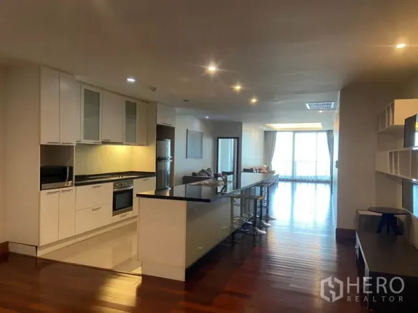 Condominium for rent in Sathon, Bangkok - Modern open kitchen with long island breakfast bar and full appliances overlooking the living space.