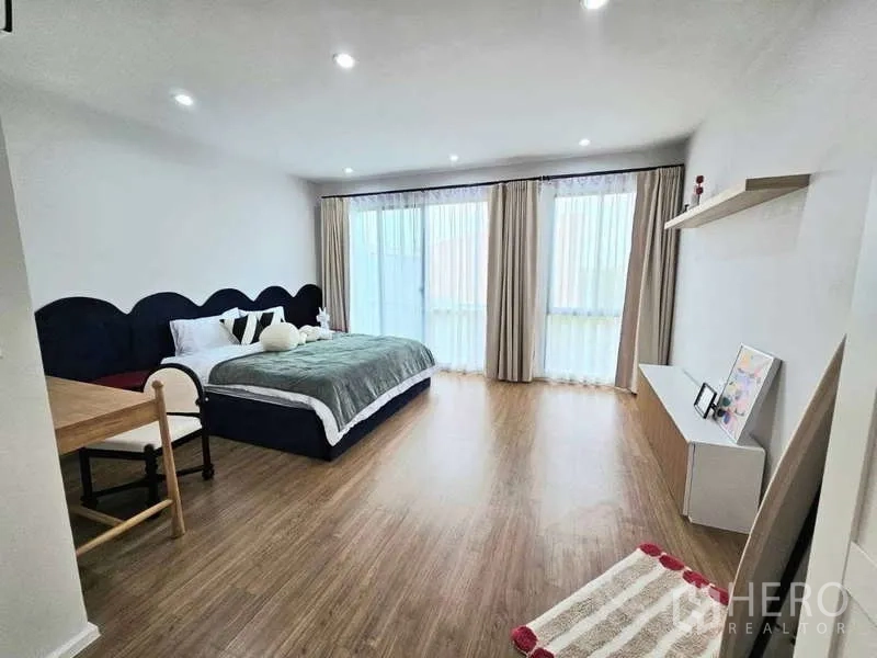 Townhouse for rent in Suan Luang, Bangkok - Oversized bedroom with king bed, long windows, floating shelves and study desk.