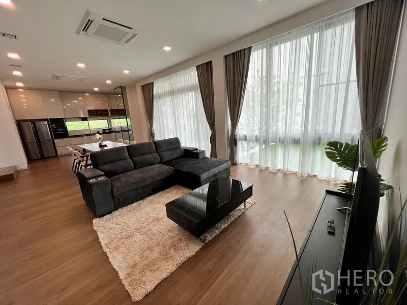 Detached House for rent - Spacious living area connected to a modern kitchen and dining zone, wrapped by tall windows.