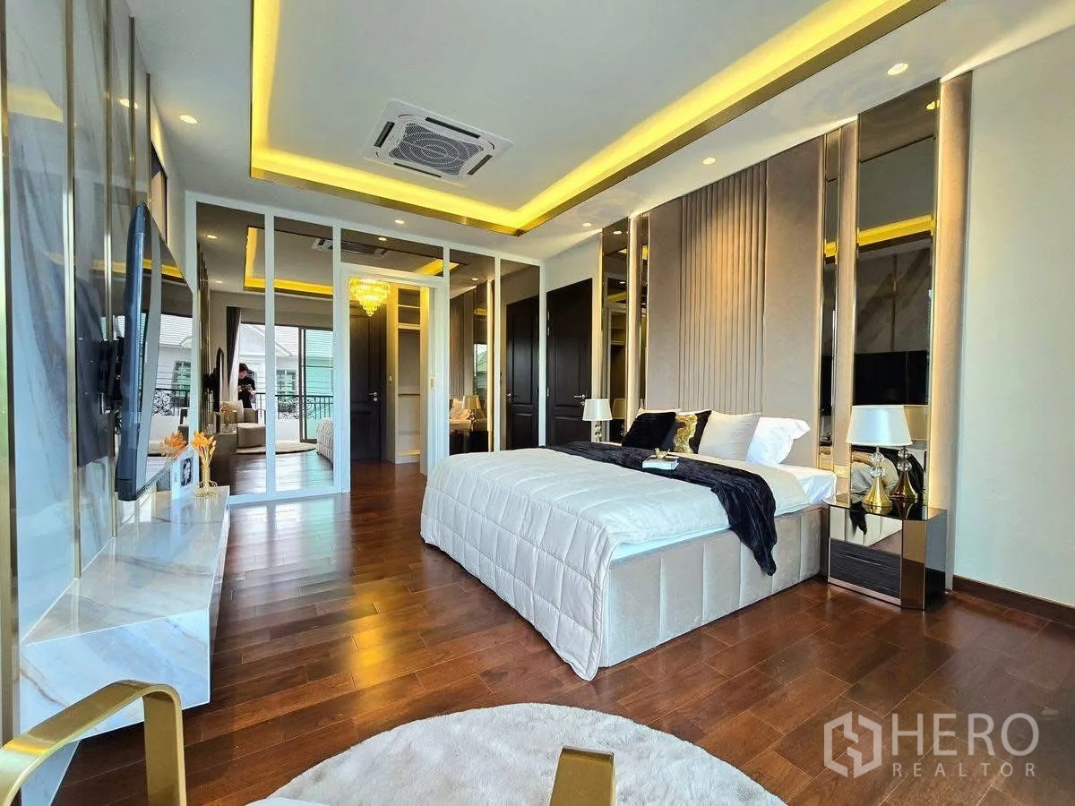 บ้านเดี่ยว for rent or sale in Bang Phli, Samut Prakan - ห้องนอนขนาดใหญ่มีผนังทีวี ประตูกระจกออกระเบียง พื้นไม้ และไฟซ่อนทอง