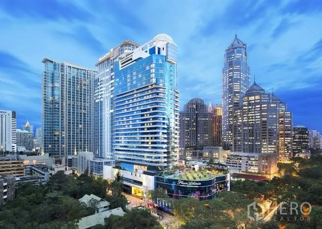 公寓 出租在Pathum Wan, Bangkok - 位于曼谷市中心的豪华高层公寓外观，黄昏灯光璀璨。