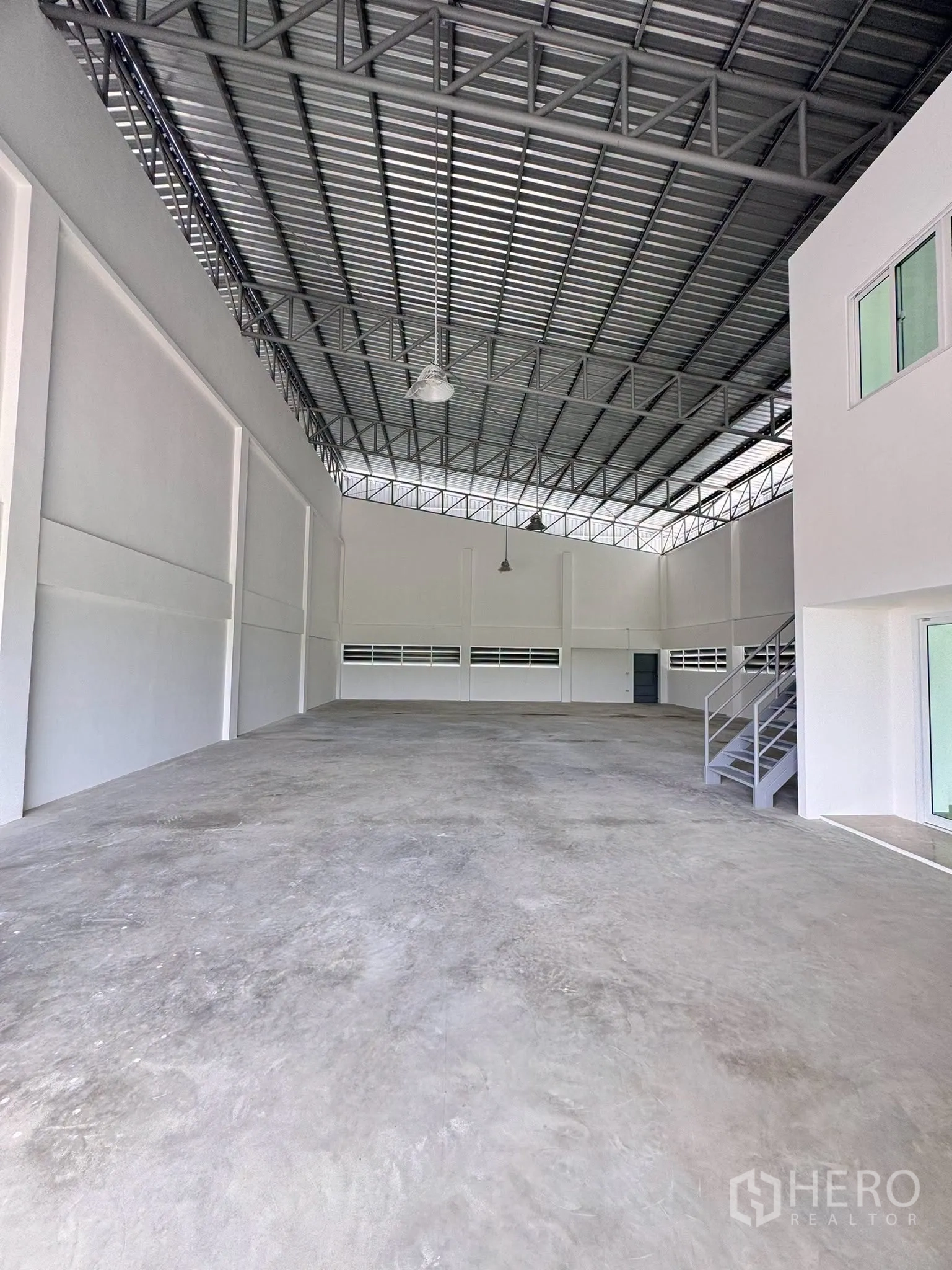 Warehouse for rent in Bang Bo, Samut Prakan - Wide warehouse bay showing a metal truss roof, open floor area, and side ventilation panels.