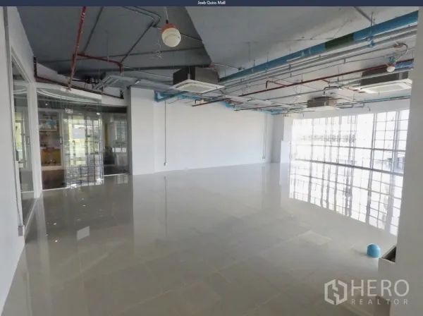 Office Space for rent in Khlong Toei, Bangkok - Spacious office area with polished flooring, glass partition entry, and modern exposed ceiling.