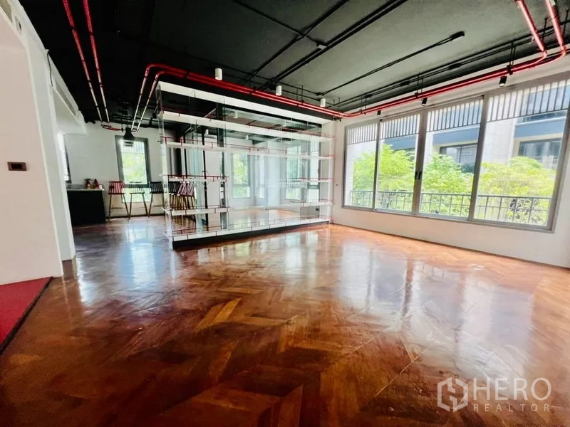 办公空间 出租在Khlong Toei, Bangkok - 宽敞办公区，镜面玻璃展示架，外露红色管线与大窗户。