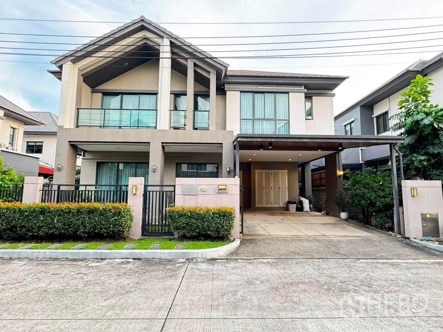 Detached House for rent in Saphan Sung, Bangkok - Modern two-story detached house with gated entry, hedges, and a covered carport.