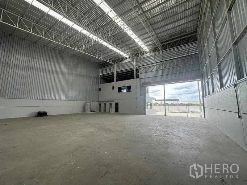Factory for rent in Wang Noi, Phra Nakhon Si Ayutthaya - Warehouse interior facing a large roller door opening to the yard and an office mezzanine.