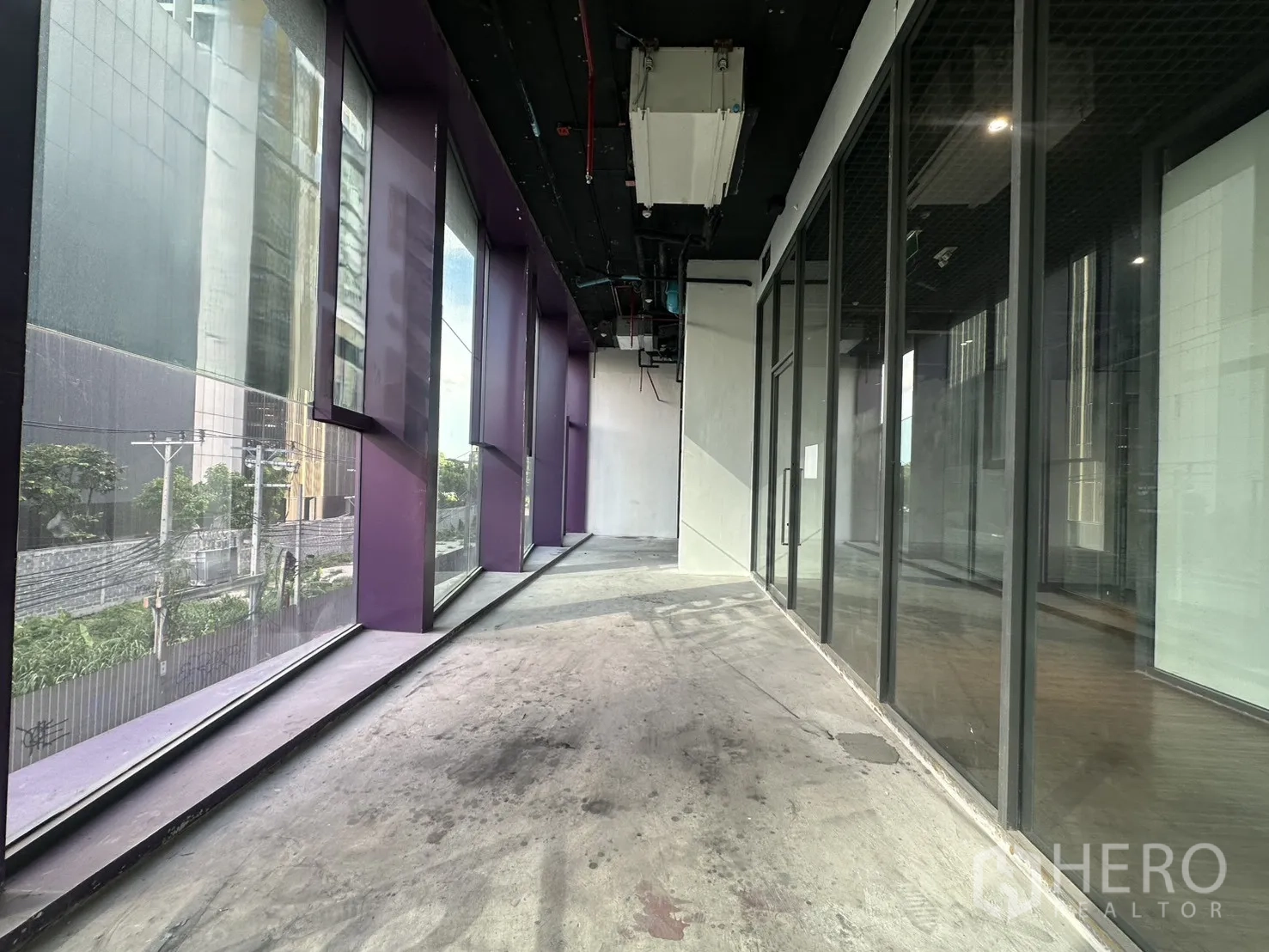零售空间 for rent in Khlong Toei, Bangkok - 窄长窗带紫色框架，对街景并连通玻璃墙。