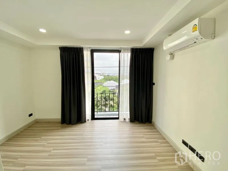 สำนักงานที่บ้าน ให้เช่าหรือขายในBang Na, Bangkok - ห้องนอนมีหน้าต่างสูงจรดเพดาน ระเบียง ผ้าม่านทึบ และเครื่องปรับอากาศติดผนัง